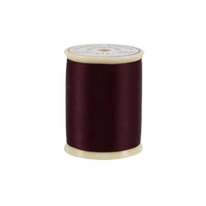 Spool of dark red thread on a white background