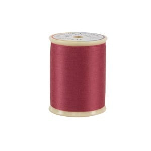 Spool of red thread on a white background
