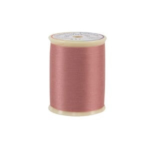 Spool of pink thread on a white background