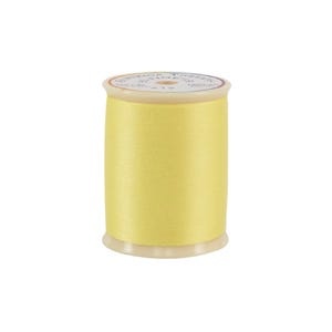 Spool of yellow thread on a white background