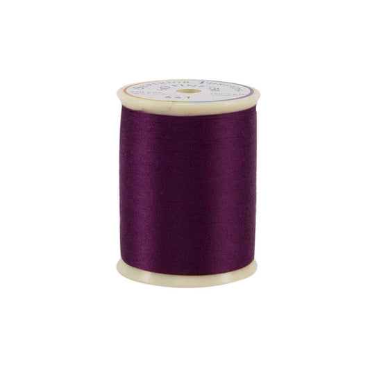 Spool of purple thread on a white background
