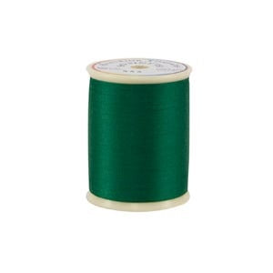 Spool of green thread on a white background