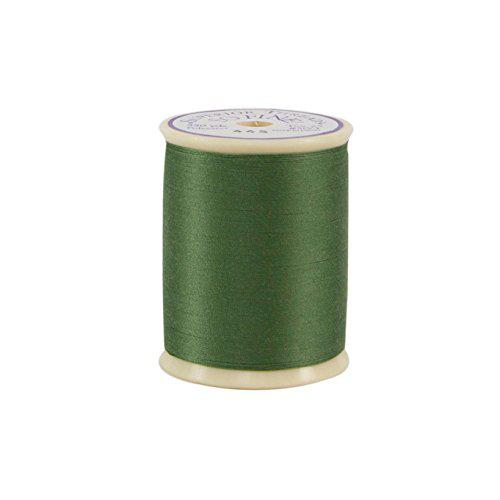 Spool of green thread on a white background