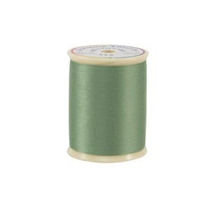 Spool of green thread on a white background