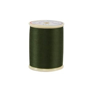 Spool of green thread on a white background