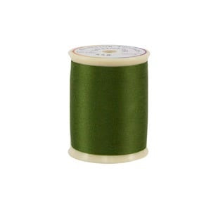 Spool of green thread on a white background