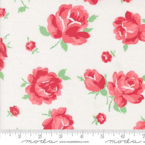 Fabric with pink roses on a white background, featuring Moda label.