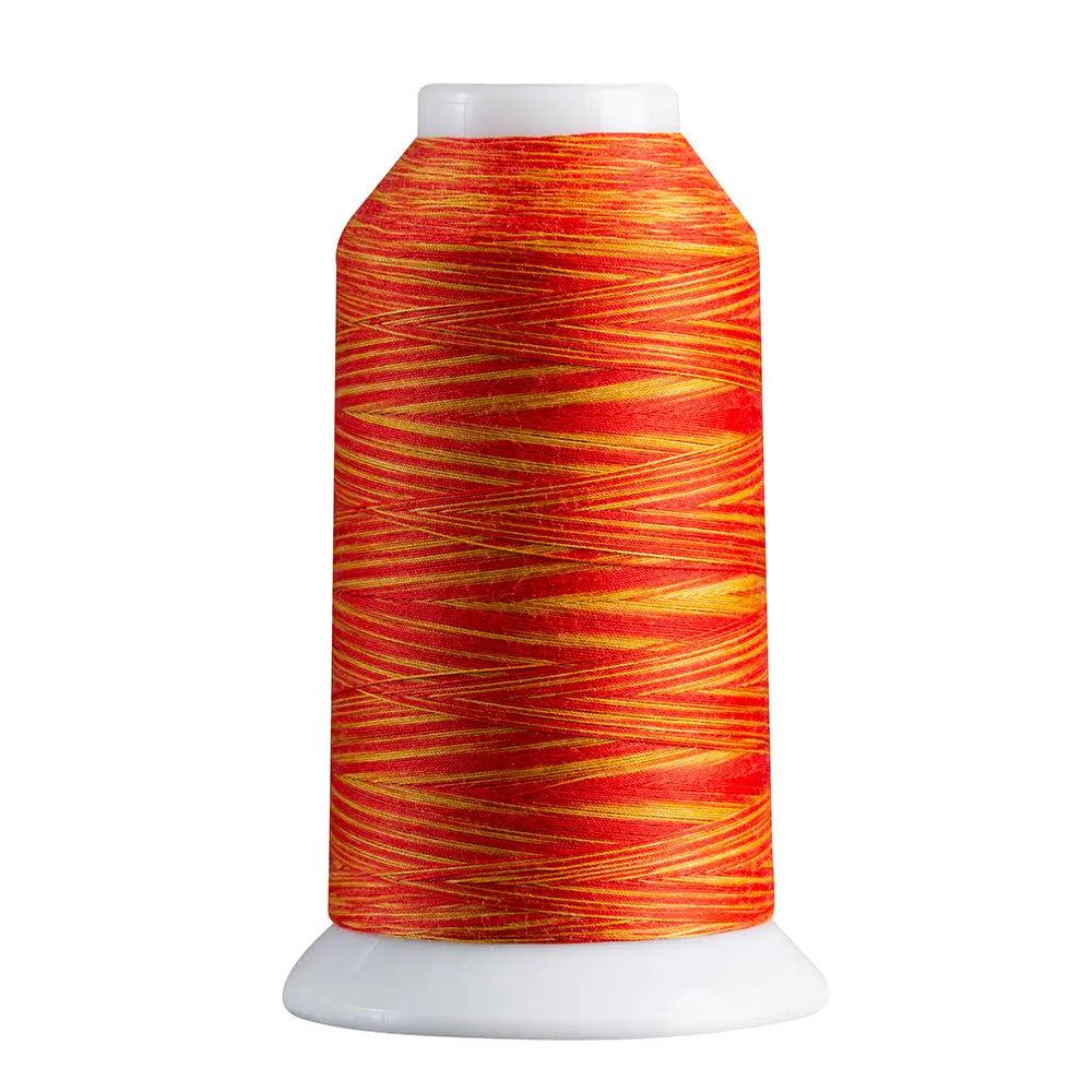Spool of red and orange thread on a white background