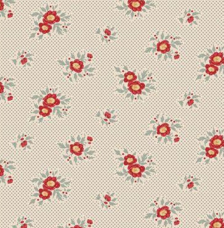 Cream background with tiny blue dots and scattered red floral bouquets with blue-green leaves.