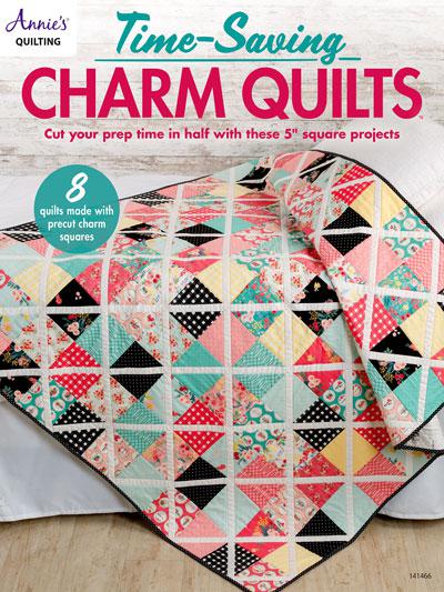 Quilt with charm squares on a wooden surface, featuring text about time-saving charm quilts.