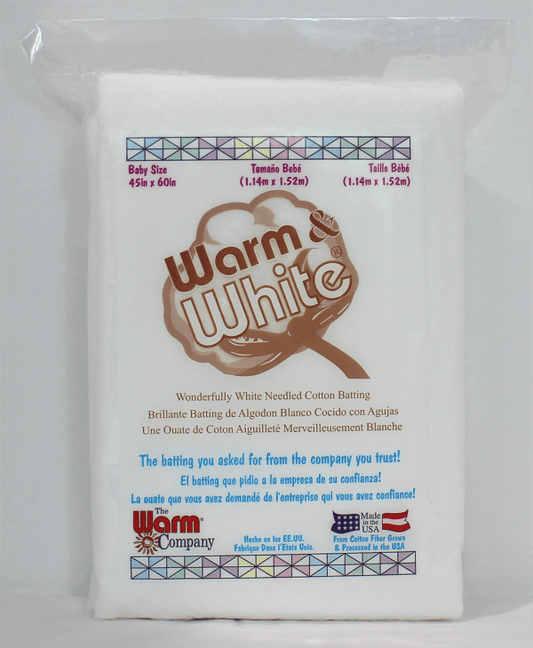 Package of Warm & White baby size cotton batting with branding and text on a white background