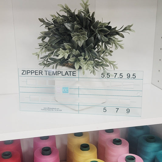 Zipper template with measurements on a shelf with spools of thread